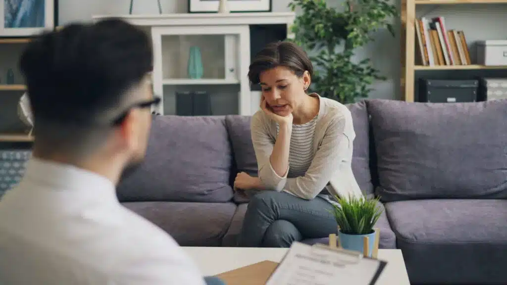 Woman talking with a therapist during an individual counseling session, sharing thoughts and emotions in a calm and comfortable setting