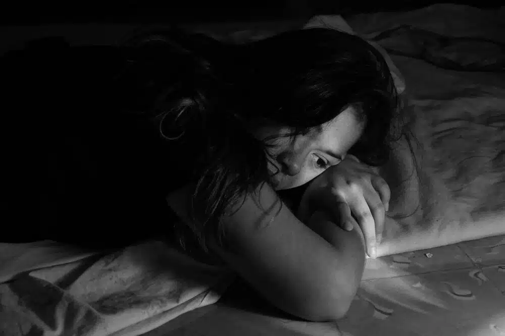 Woman lying awake in emotional distress, representing depression, anxiety, and emotional overwhelm counseling support.