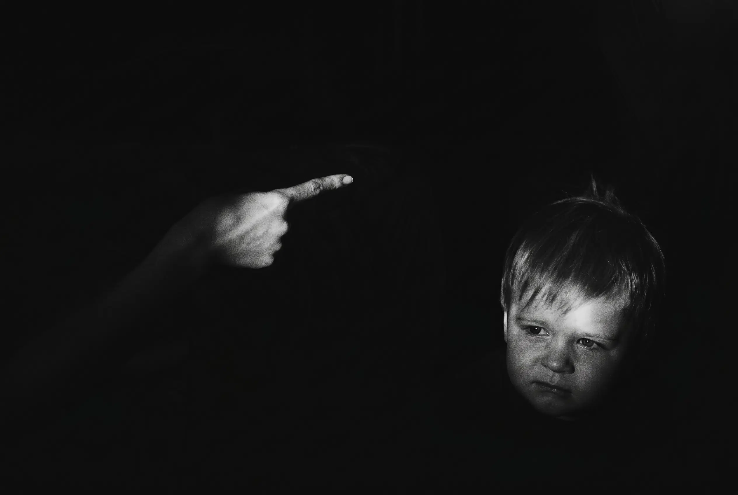 Dark dramatic image of a child representing the impact of childhood trauma and the need for faith-based counseling and healing