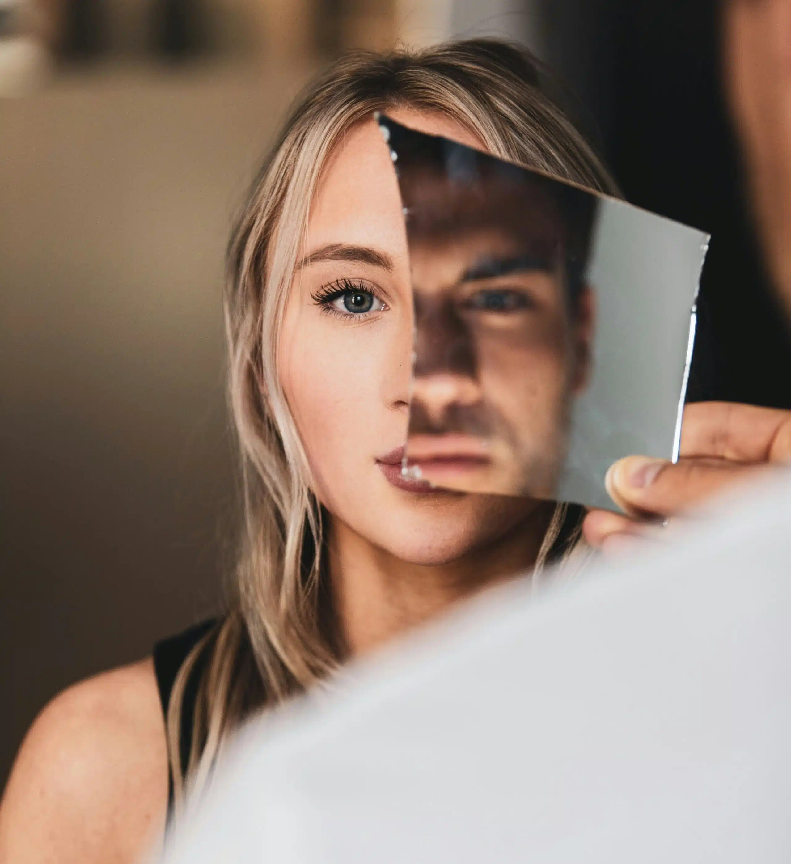 a man holding a mirror while looking at a woman
