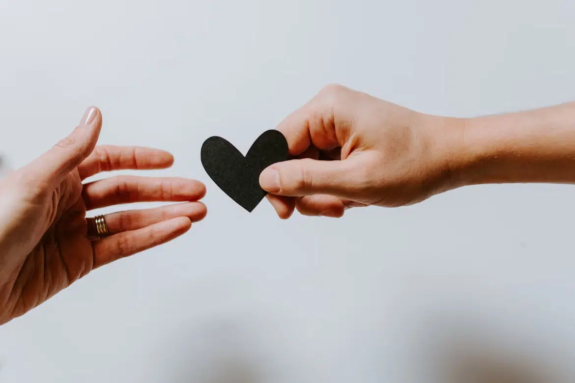 Two people exchanging a paper heart symbolizing emotional boundaries in Christian relationships