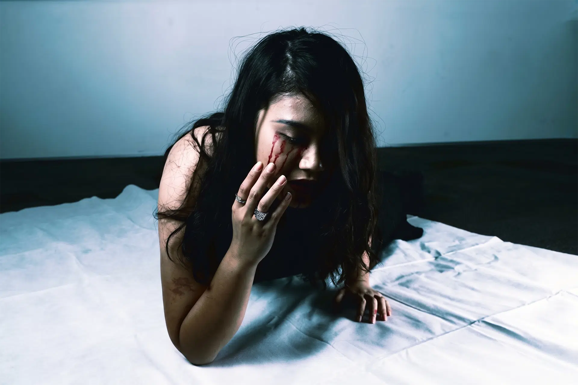 Woman sitting alone in distress representing the weight of generational trauma and emotional pain in Christian families