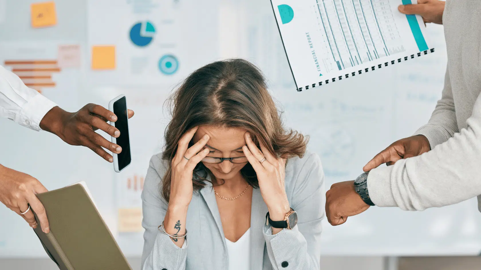 Woman holding her head at a desk as colleagues hand her a phone, files, and reports, overwhelmed by constant workplace demands.