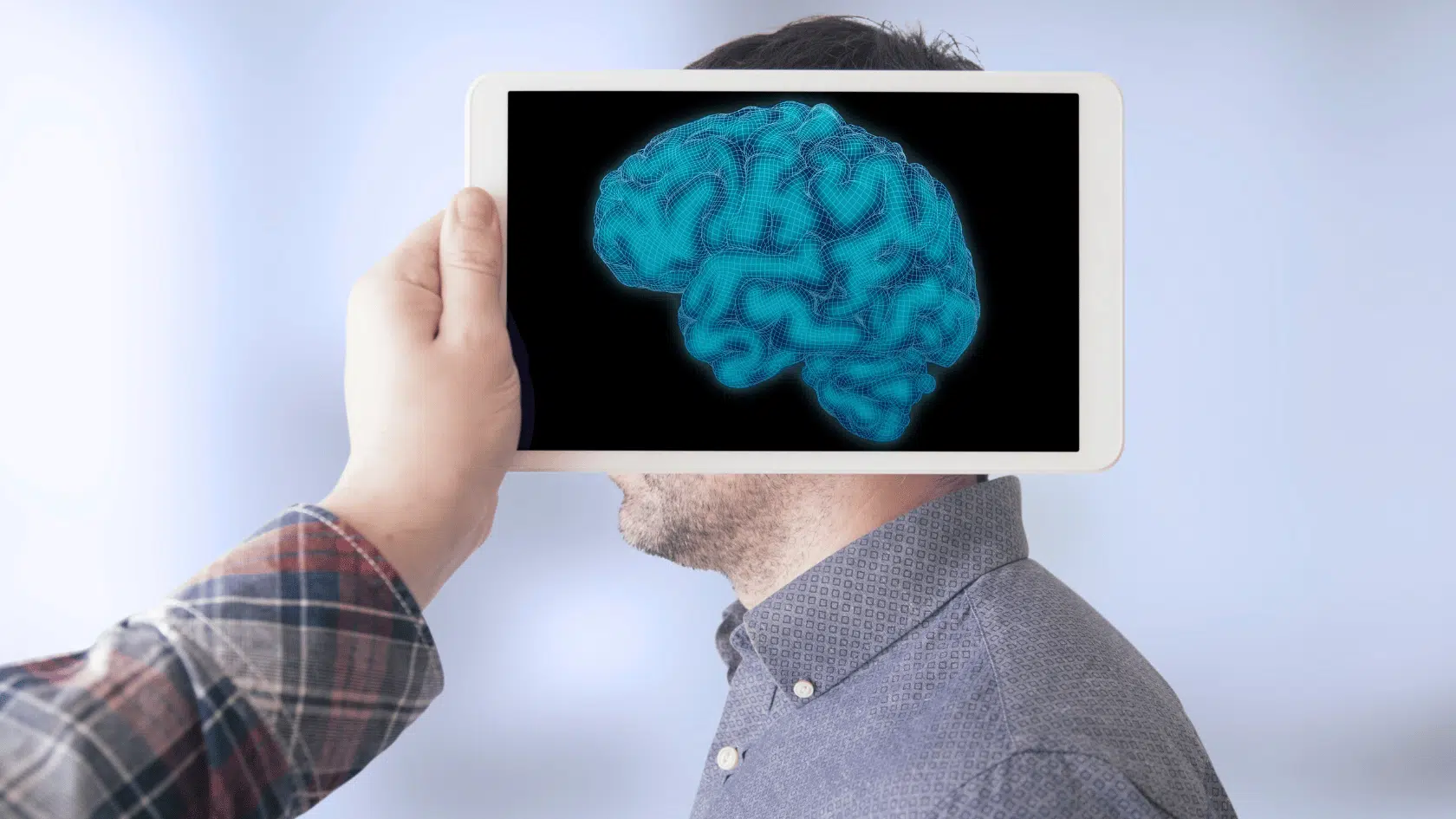 Person holding a tablet displaying a glowing digital brain, illustrating how brain based therapy reaches the deeper subcortical brain.